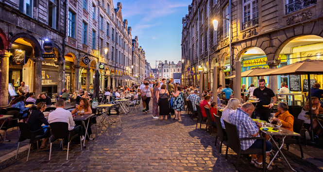 Busy outdoor street cafes at sunset on the cobblestones of Arras, France