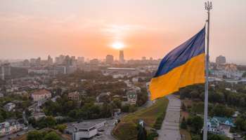 Aerial view of the Ukrainian flag waving in the wind against the city of Kyiv